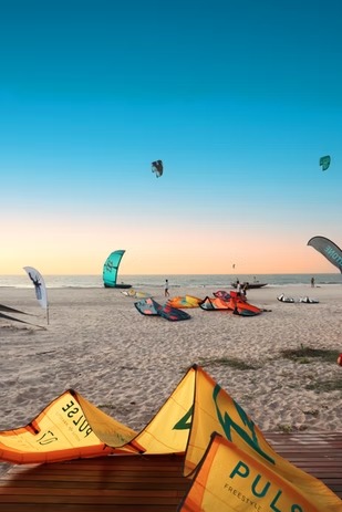 Pipas de kitesurf na areia ao entardecer em Camocim